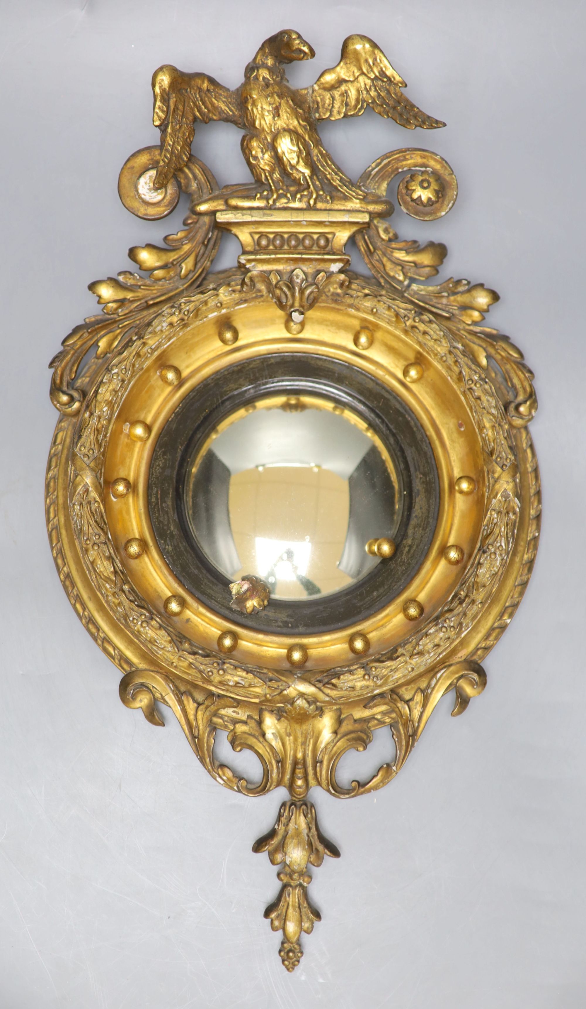 A small Regency style giltwood and gesso convex wall mirror, overall length 49cm